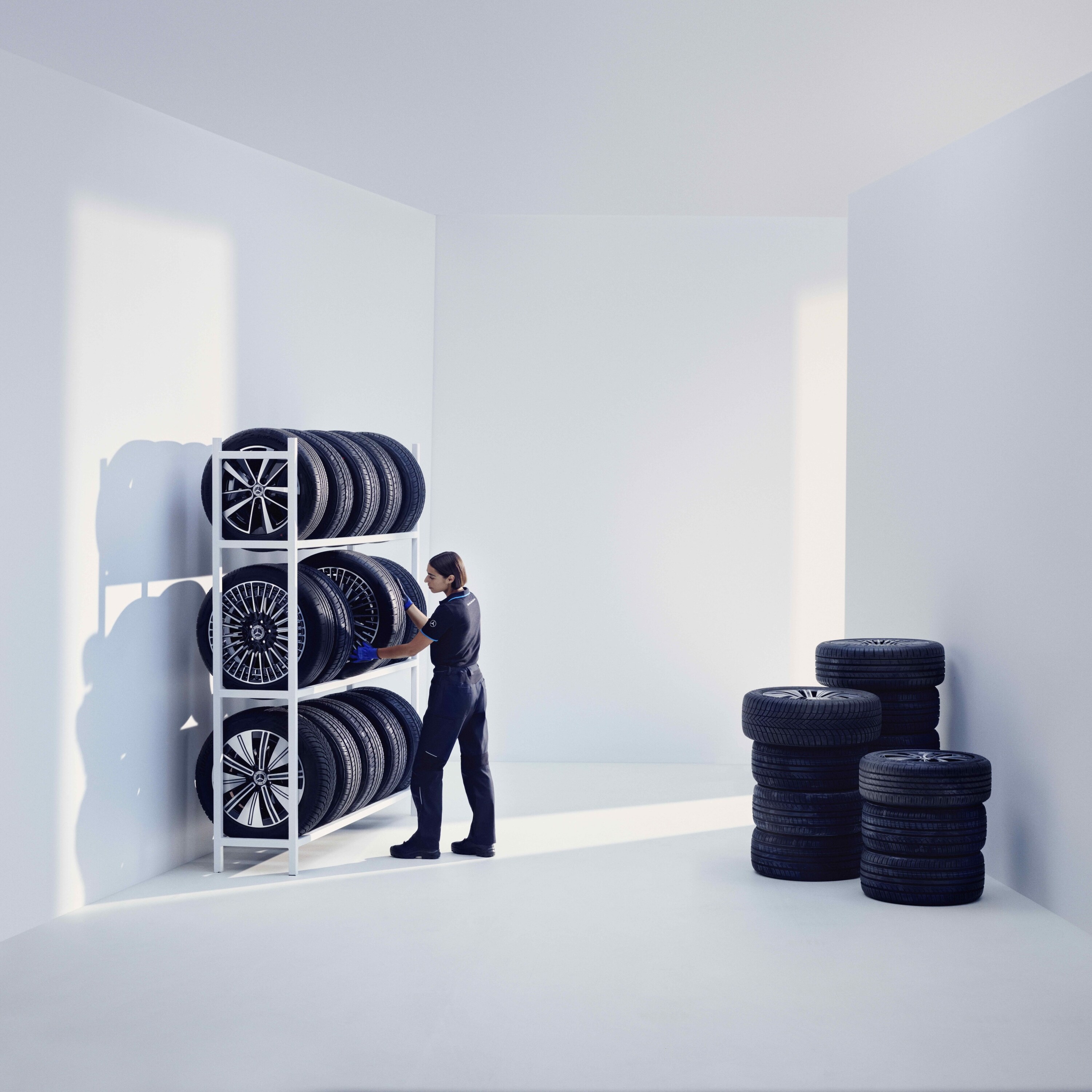 Mercedes-Benz 기술자가 선반에 Mercedes-Benz 순정 타이어를 보관합니다.