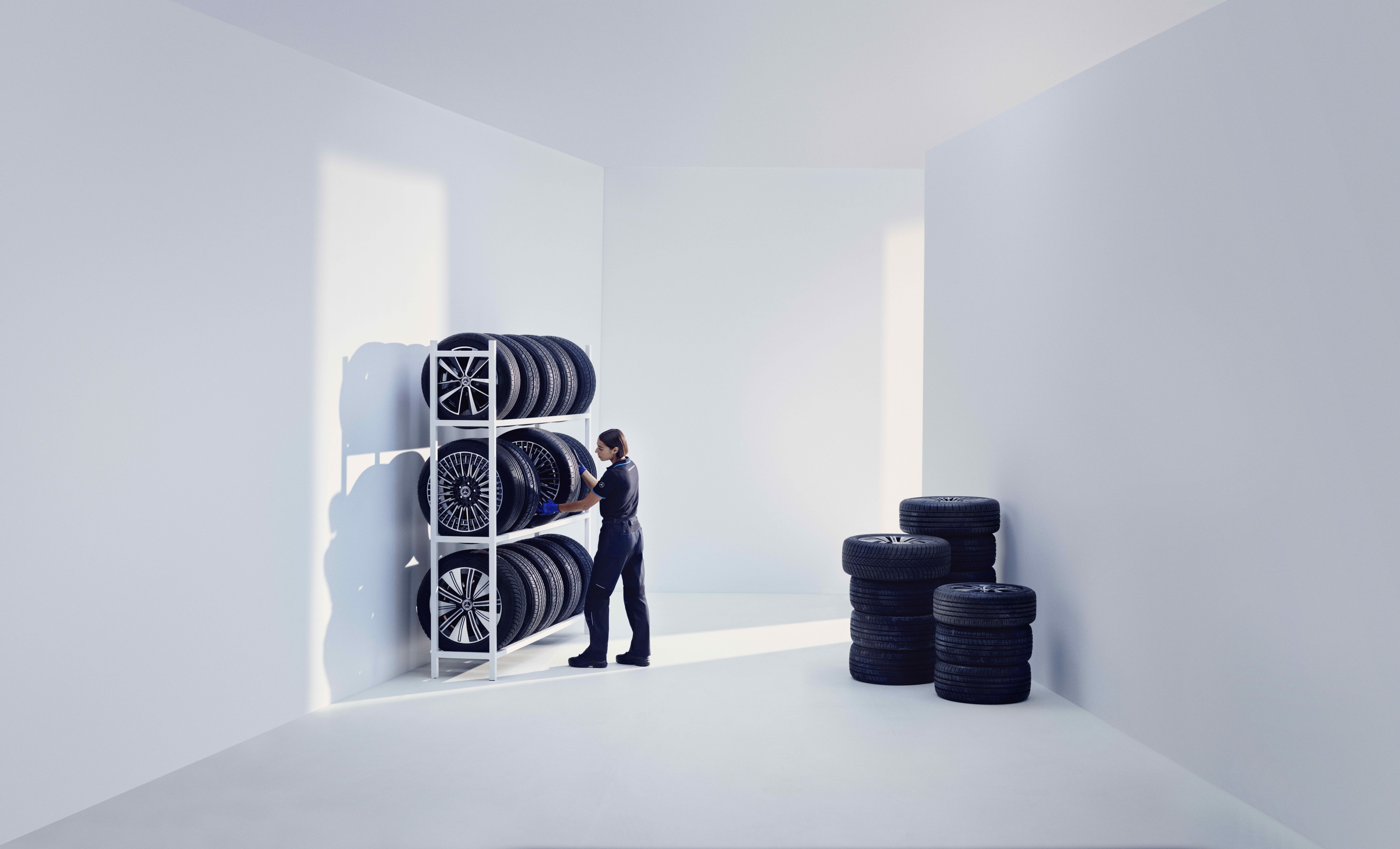 순정 타이어 | Mercedes-Benz Mercedes-Benz 기술자가 선반에 Mercedes-Benz 순정 타이어를 보관합니다.