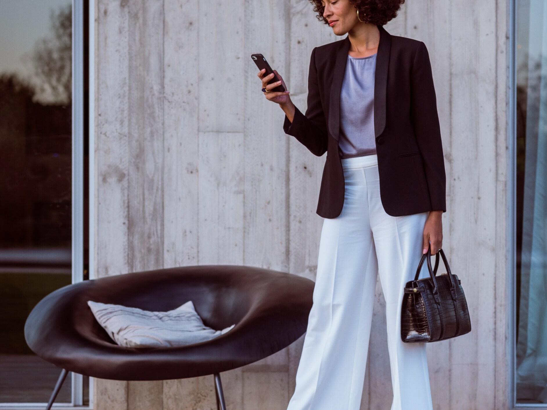 한 여성이 스마트폰, Mercedes me App 및 Mercedes me ID를 사용하여 메르세데스-벤츠 차량에 연결하고 있습니다.