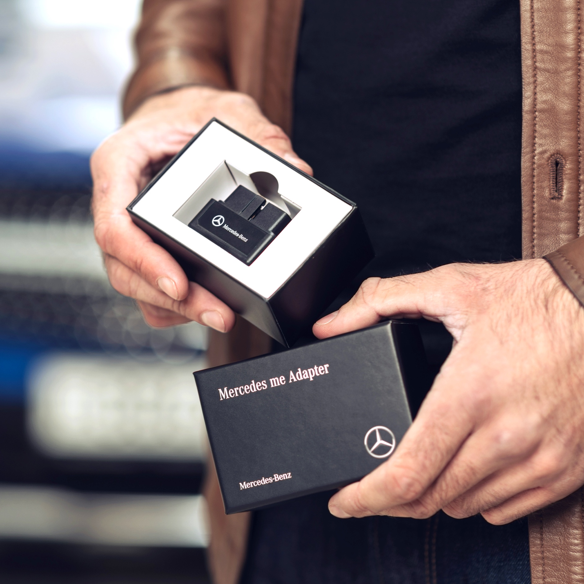 한 남성이 자신의 차량에서 디지털 서비스 상품을 사용하기 위해 메르세데스-벤츠용 Mercedes-Benz Adapter의 포장을 풀고 있습니다. 한 남성이 자신의 차량에서 디지털 서비스 상품을 사용하기 위해 메르세데스-벤츠용 Mercedes-Benz Adapter의 포장을 풀고 있습니다.