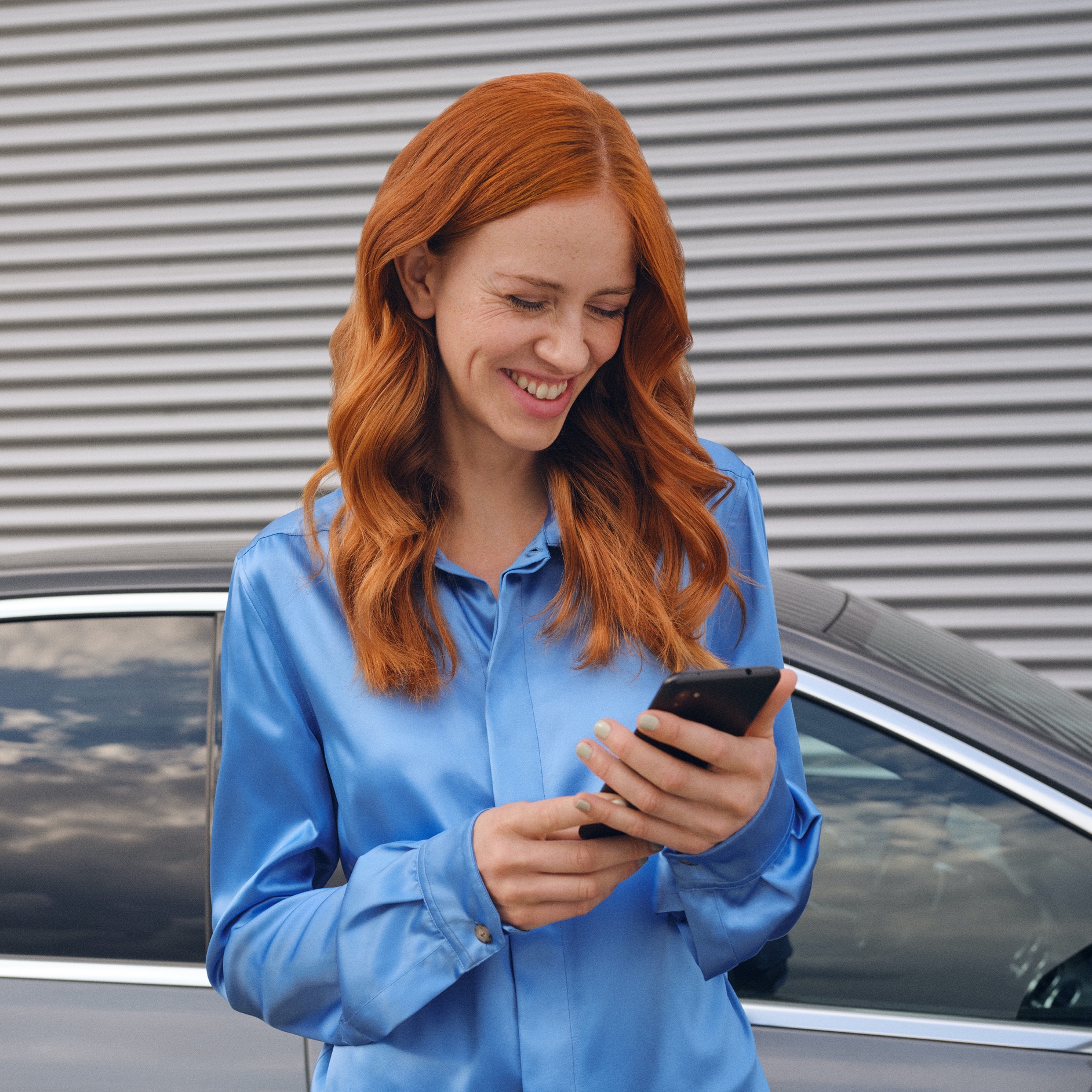 한 여성이 스마트폰에서 Mercedes-Benz App을 이용하여 메르세데스-벤츠 차량에 연결하고 있습니다. 한 여성이 스마트폰에서 Mercedes-Benz App을 이용하여 메르세데스-벤츠 차량에 연결하고 있습니다.