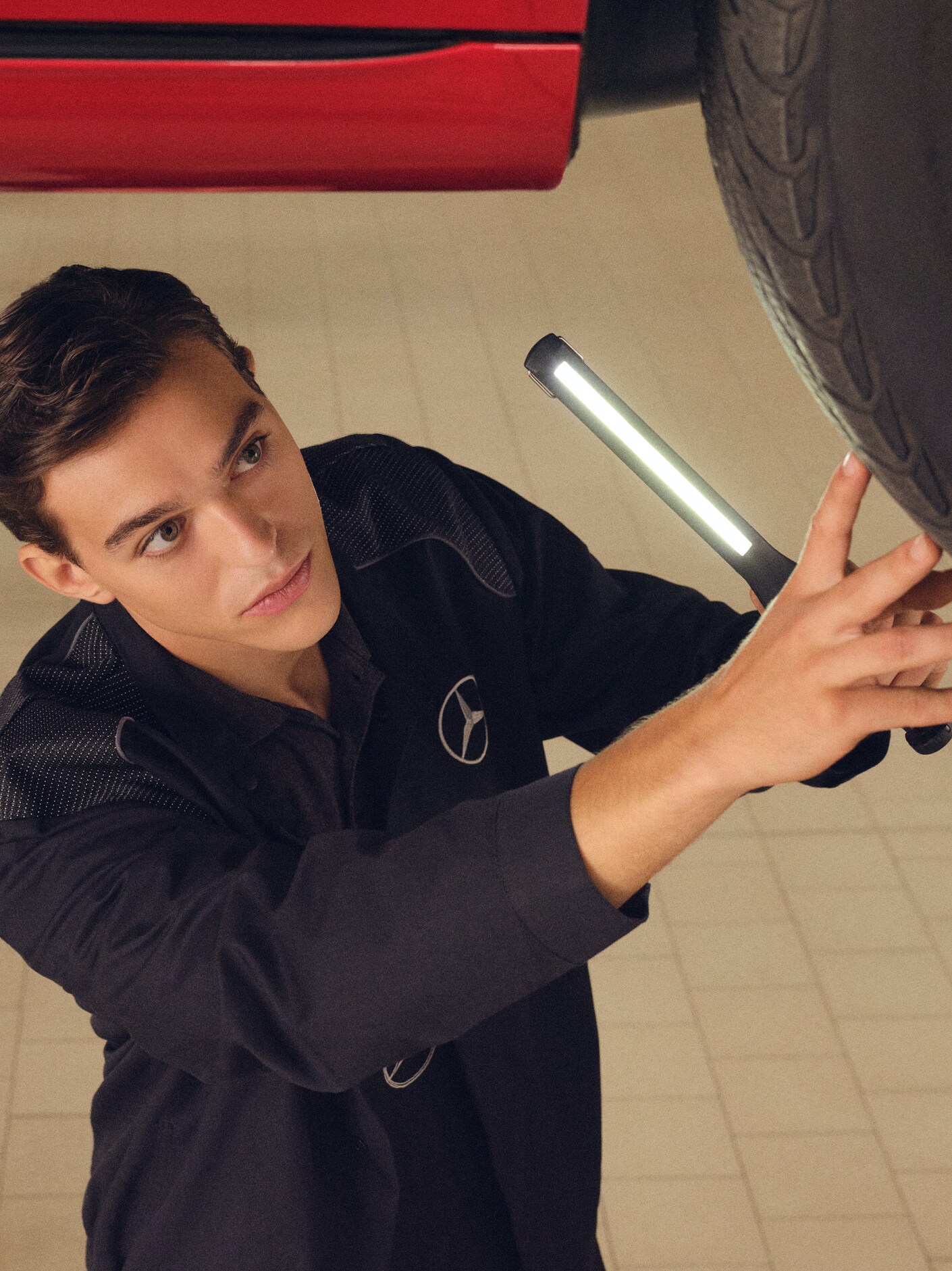 메르세데스-벤츠 엔지니어가 테스트 스탠드의 차량을 점검하고 있습니다.