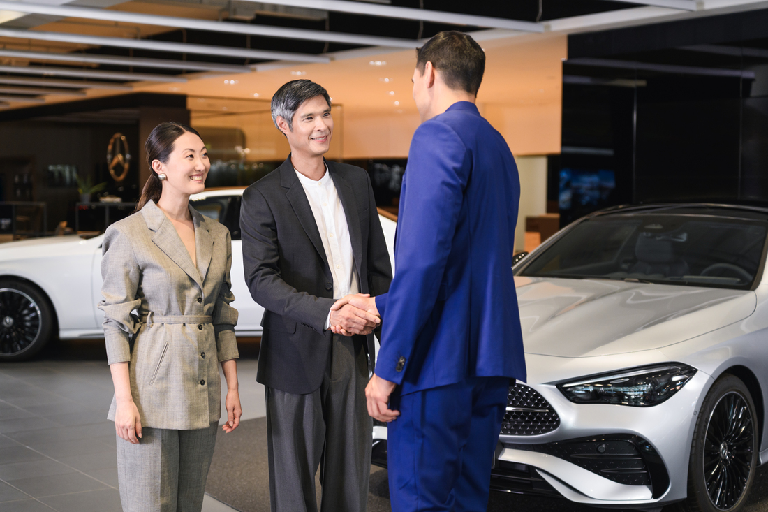신차 | 리스 & 금융 서비스 | 금융 서비스 | 메르세데스-벤츠 Man and woman sitting in blue Mercedes-Benz EQS with dealer showing vehicle features